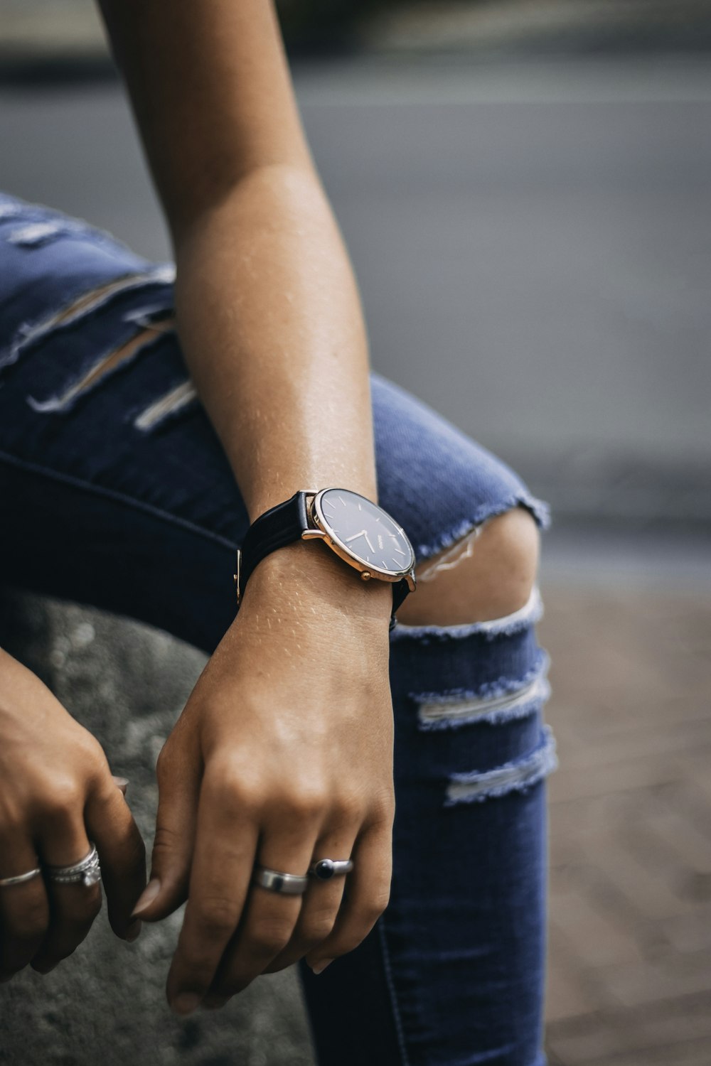 sitting person wearing silver-colored analog watch