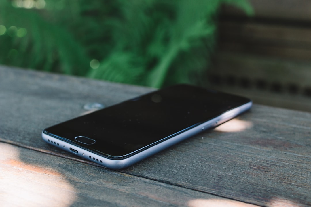 turned-off black and silver smartphone on brown wooden board