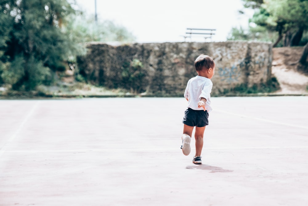 toddler running on gray concrete floor