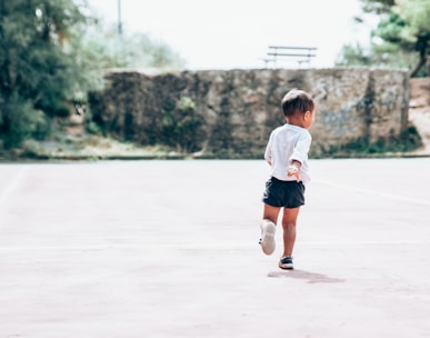 toddler running on gray concrete floor