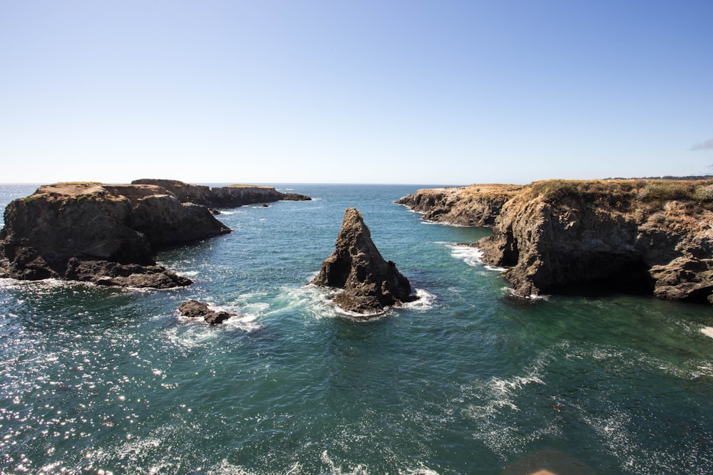 rock formation surrounded by body of water