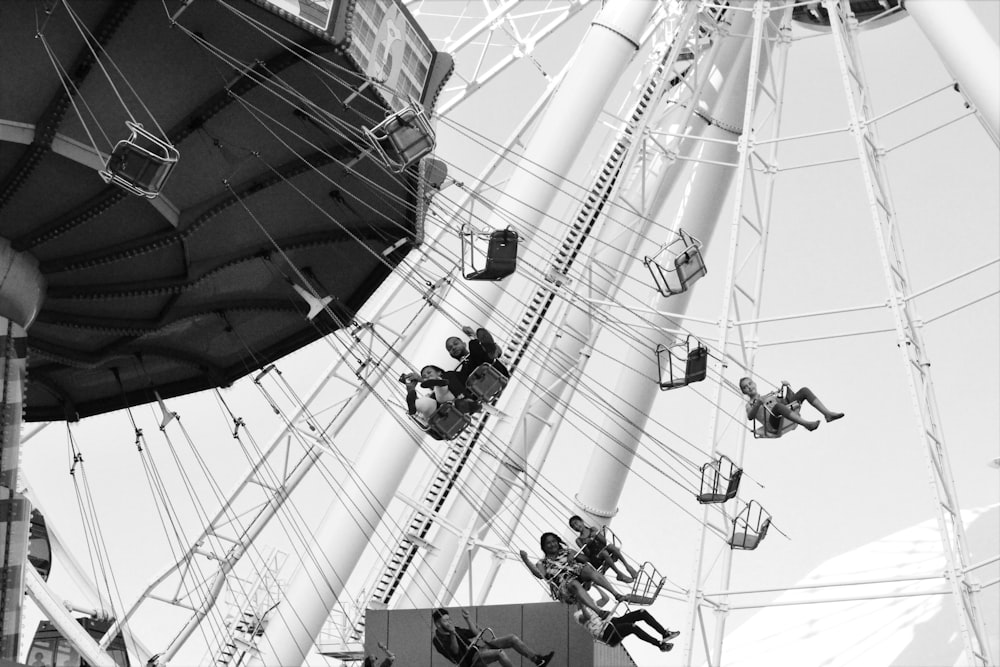 grayscale photo of people riding amusement park ride