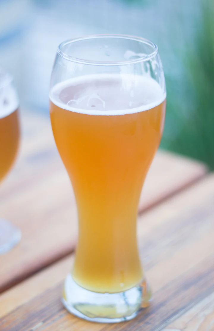 Hazy wheat beer in a tall glass, soft daylight