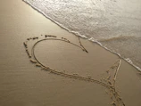 handwritten heart on sand