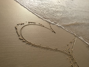 handwritten heart on sand