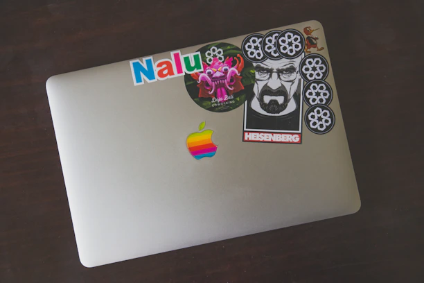 A sleek laptop adorned with several colorful, custom-cut stickers from treestick.
