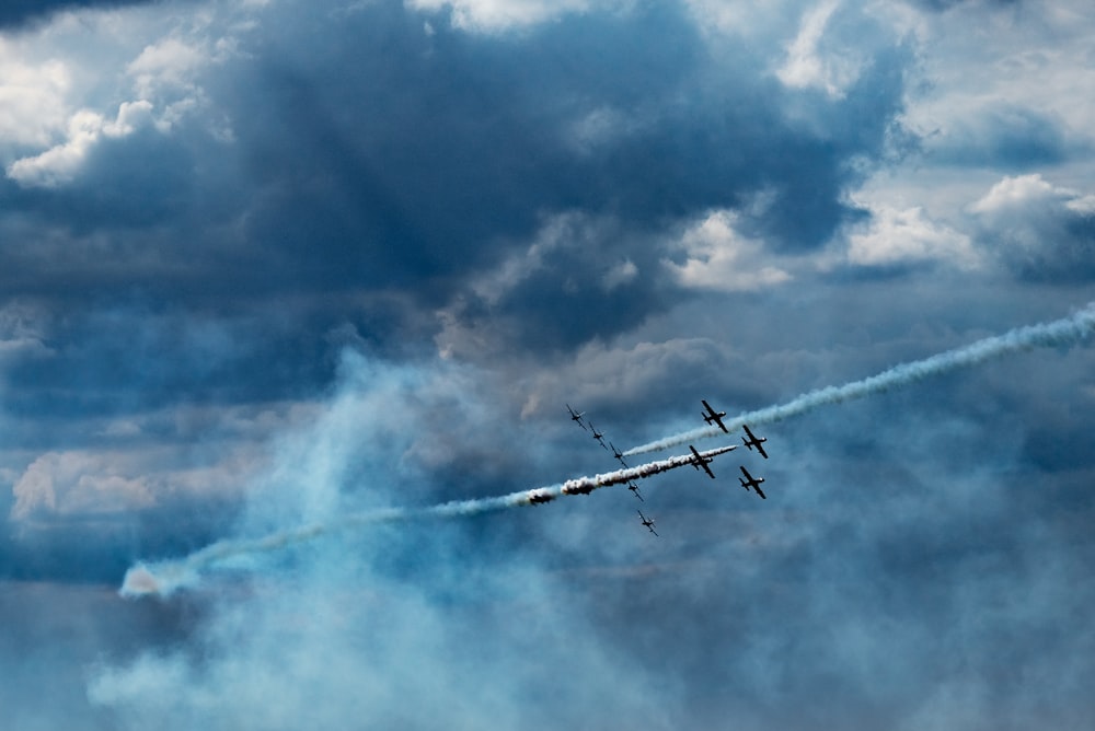 um grupo de aviões voando através de um céu nublado