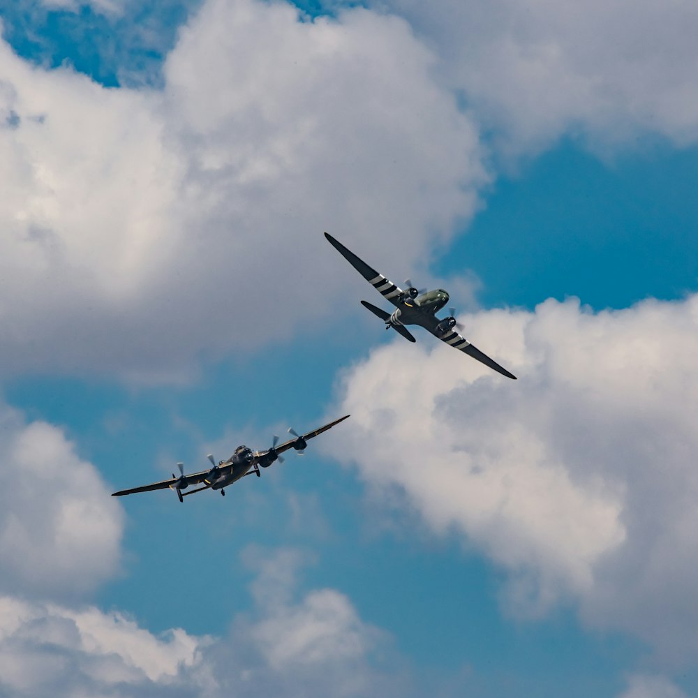 two planes under white clouds during daytime