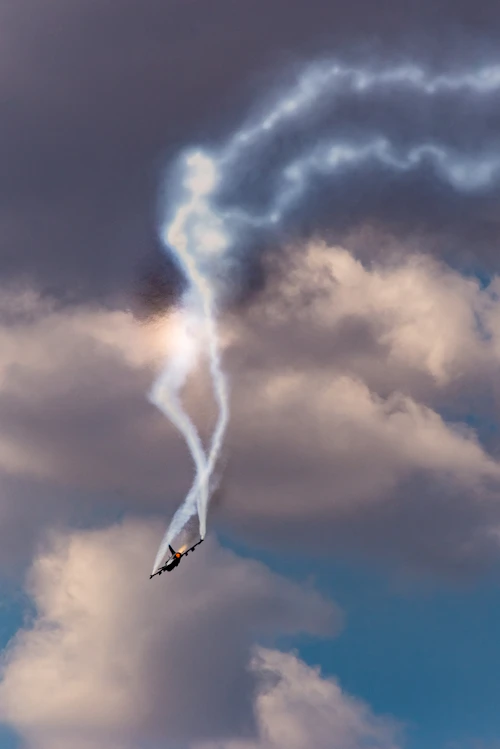 Airplane silhouette flying through dark storm clouds