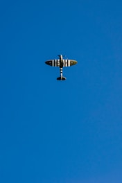 gray and white airplane under blue sky