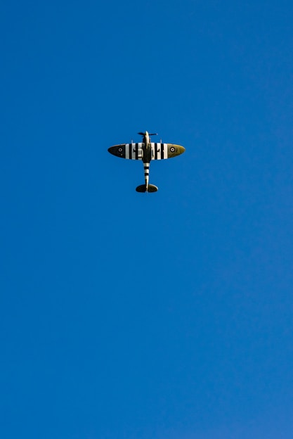 gray and white airplane under blue sky
