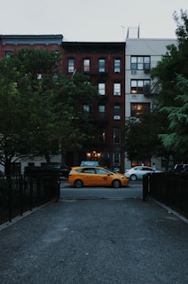 orange taxi cap parked near between open gate and building