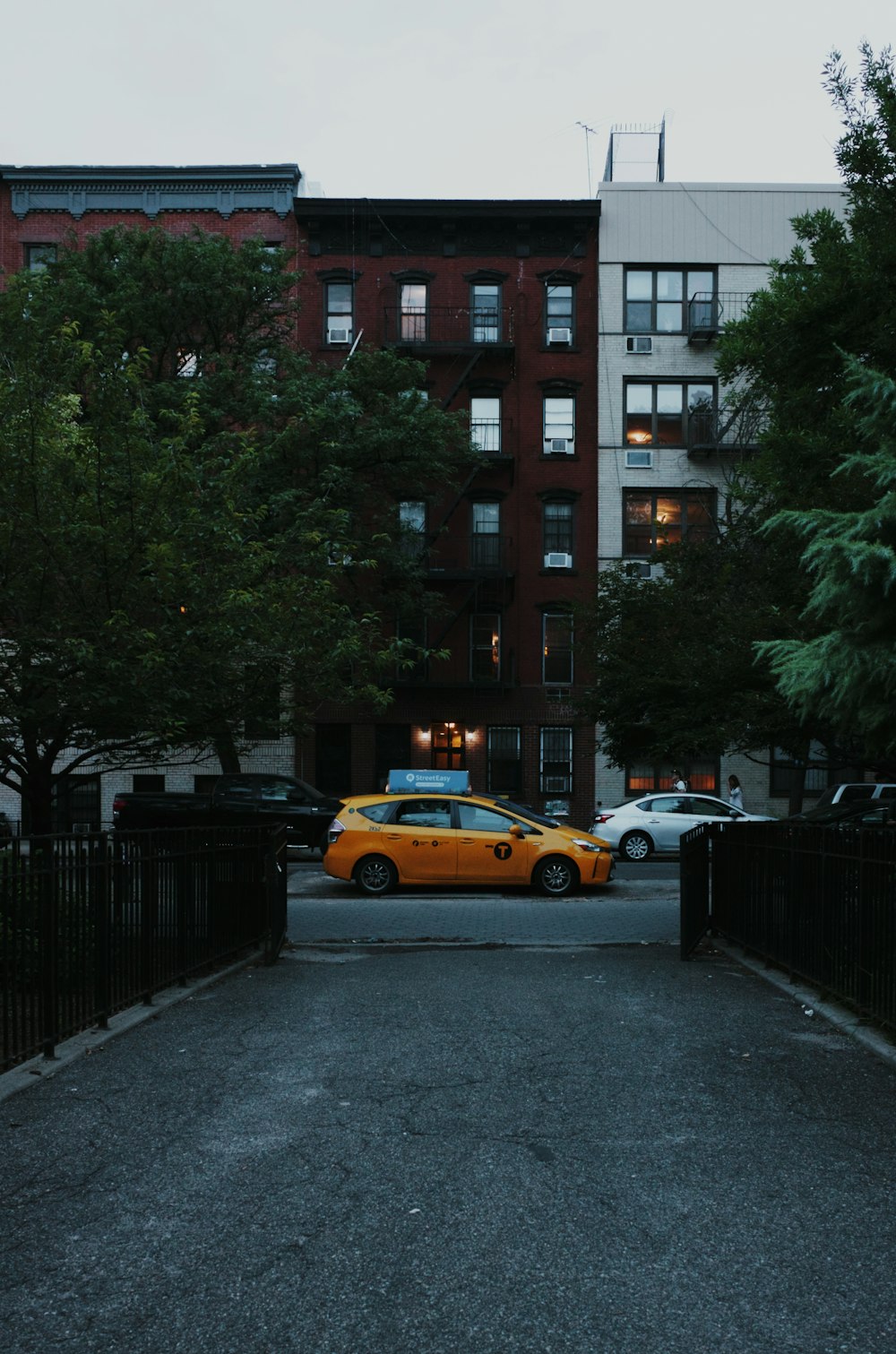 orange taxi cap parked near between open gate and building