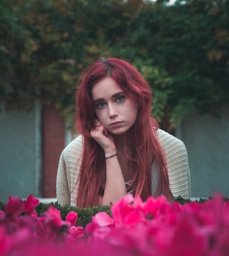 woman wearing grey shirt near pink petaled flowers during daytime