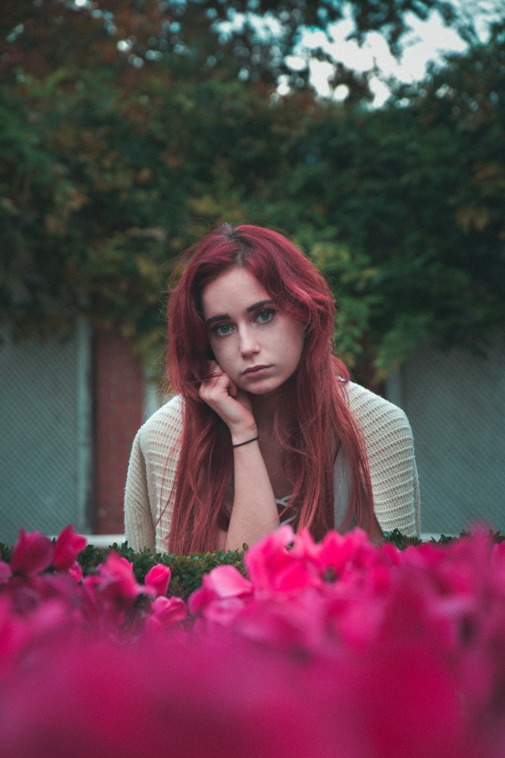 woman wearing grey shirt near pink petaled flowers during daytime