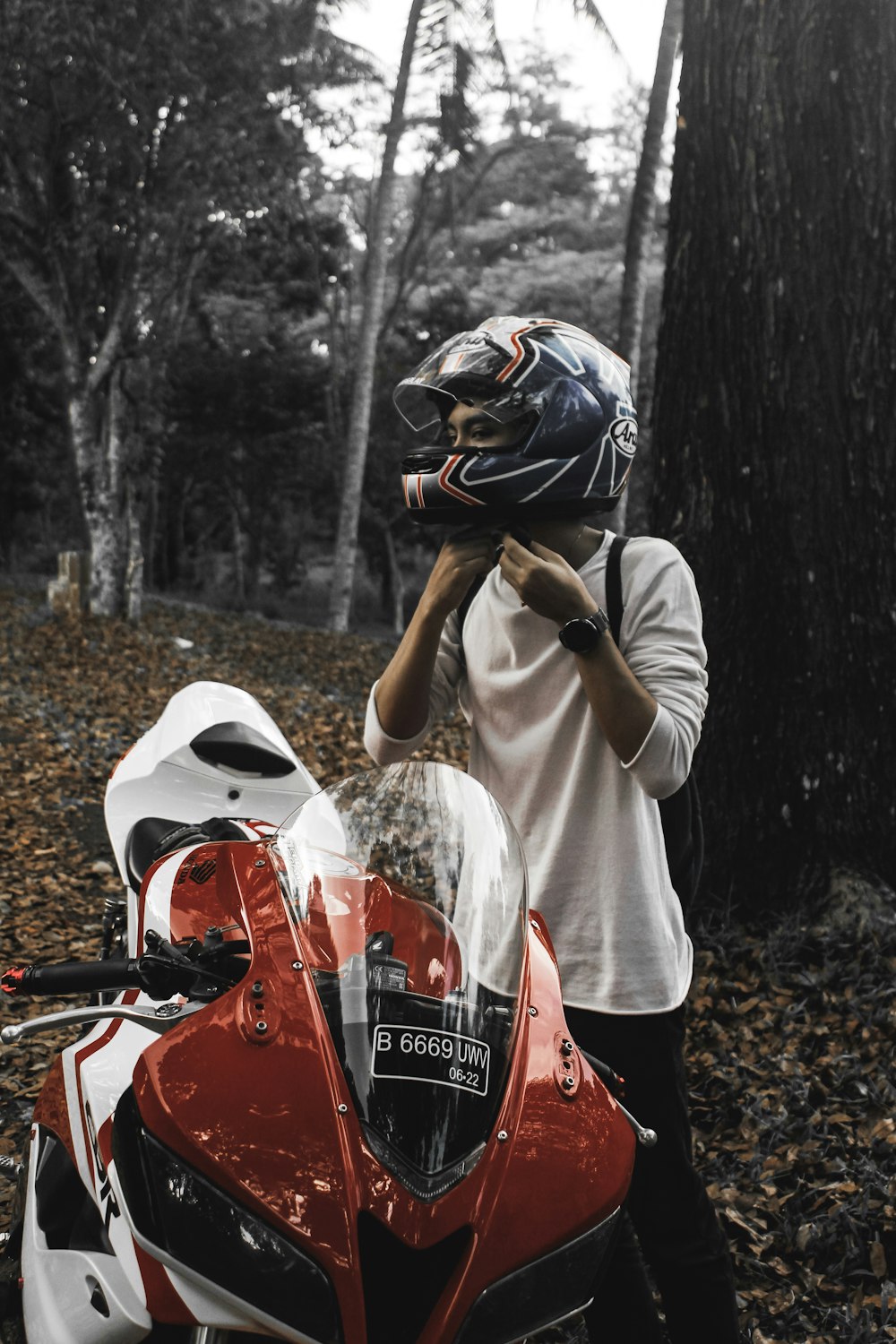 person wearing full-face helmet while standing near sports bike at daytime