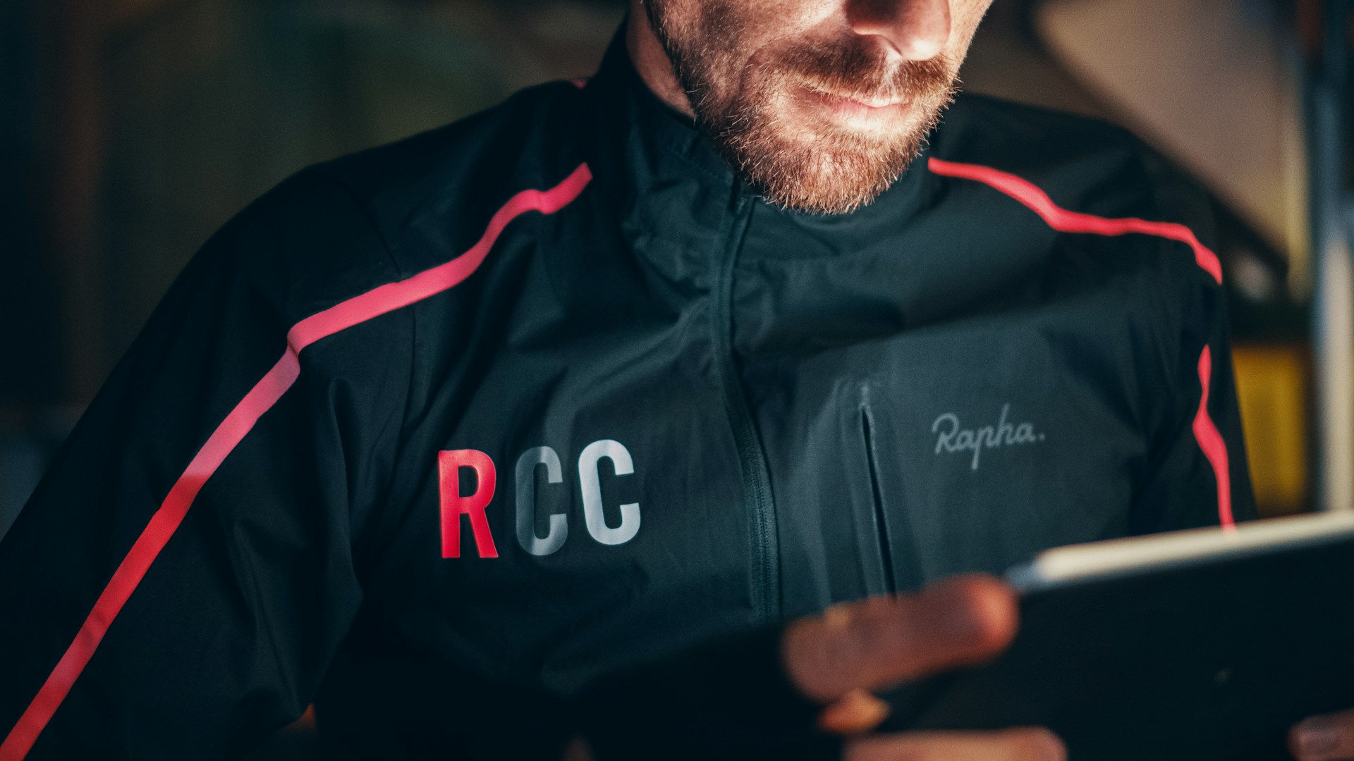 man wearing jacket and holding tablet