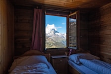 A cozy room with a large window showcasing a stunning mountain view.