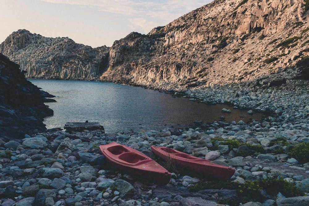 two red boats near body of water during daytime