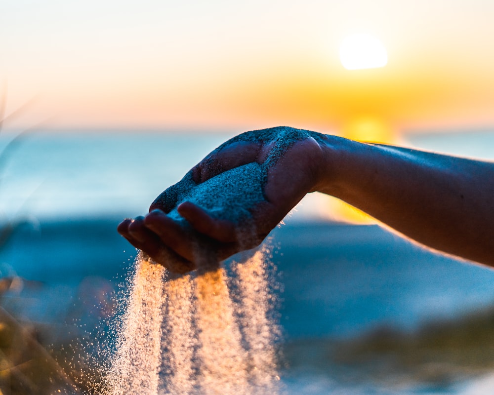 person holding brown sand