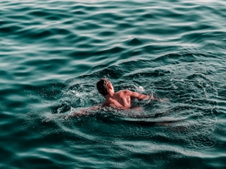 man swimming on water