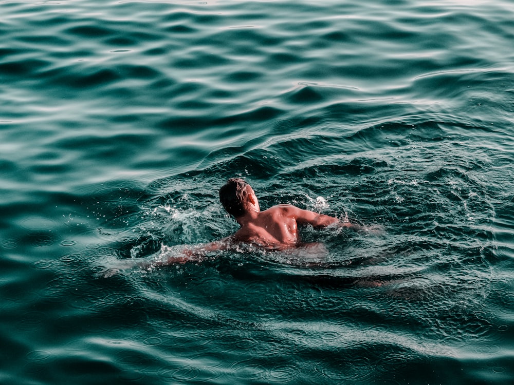 man swimming on water