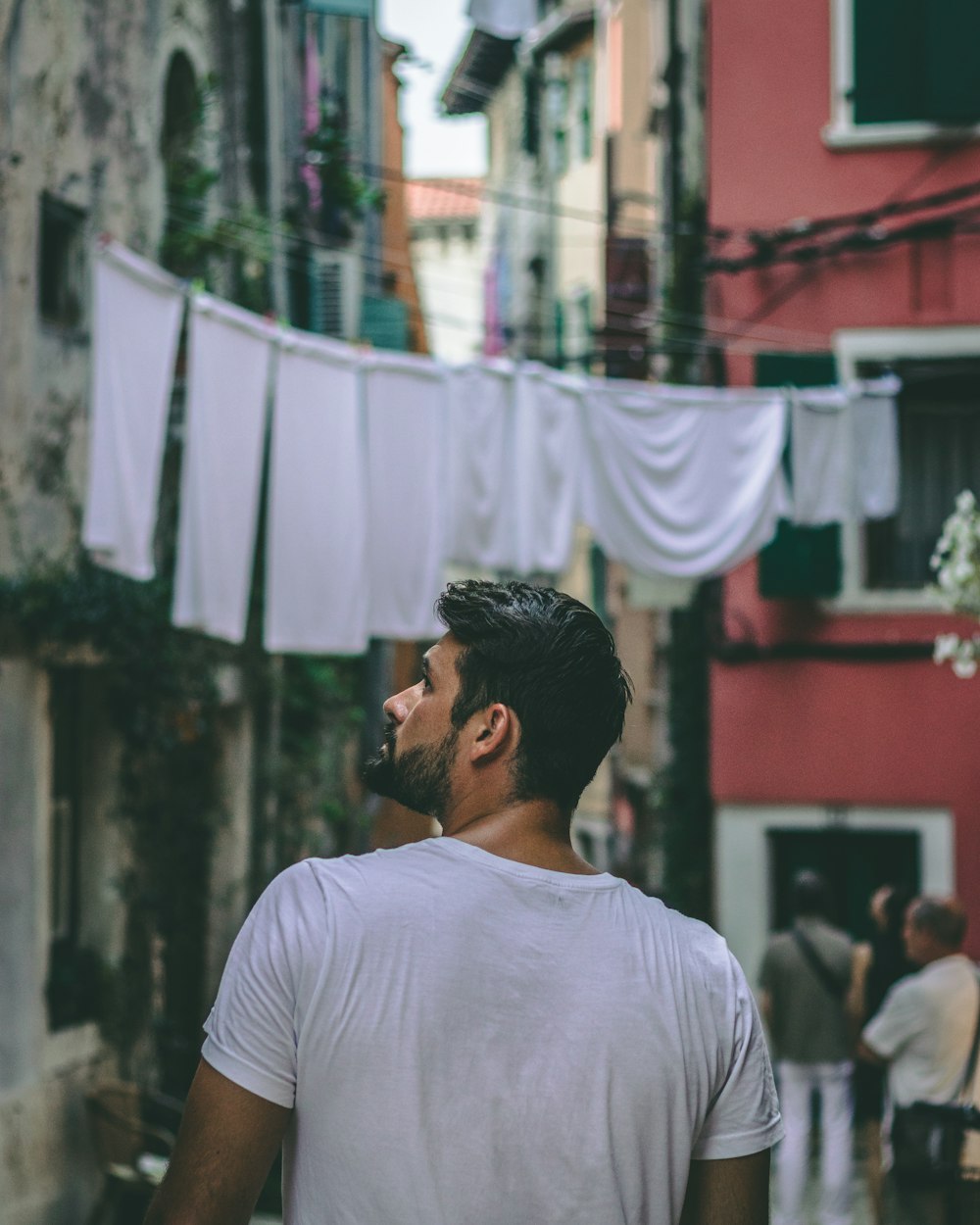 Photo de mise au point sélective d’un homme debout près d’un bâtiment en béton rose et blanc