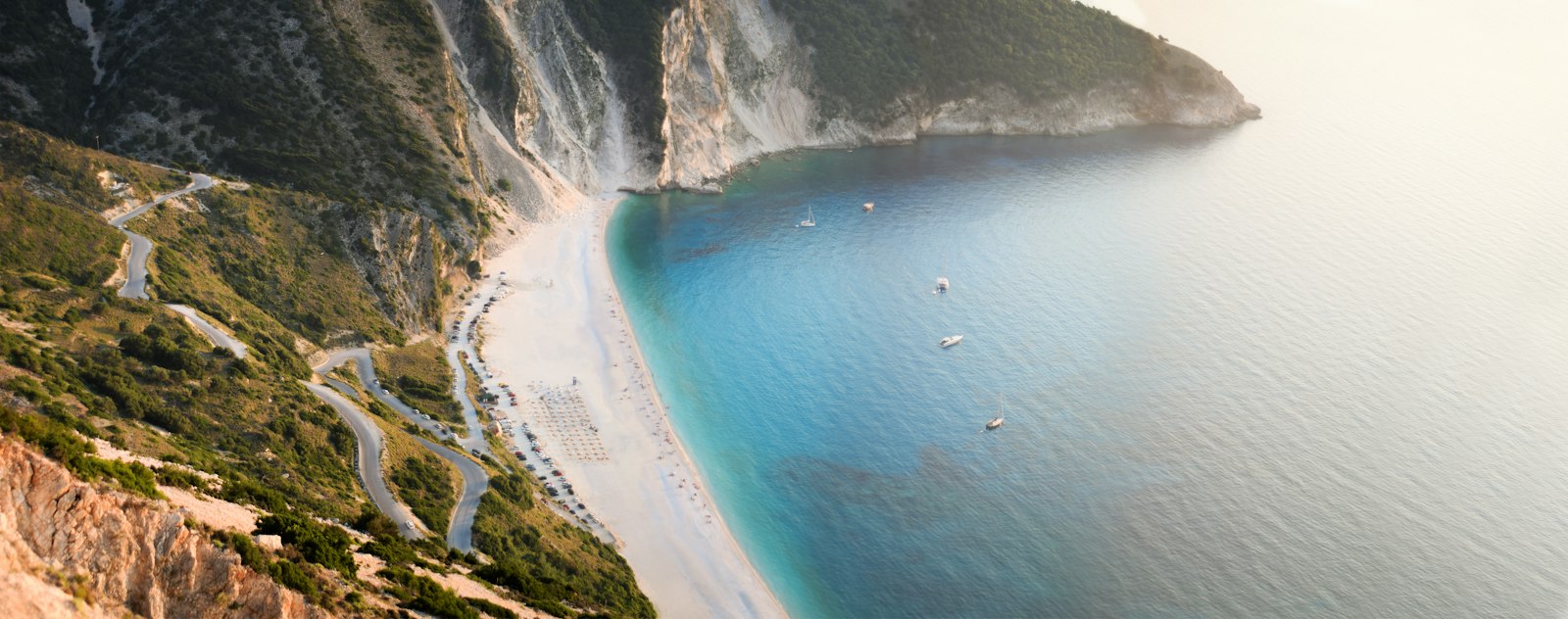 Panoramic view of Myrtos Beach on Kefalonia, a white crescent beneath steep cliffs