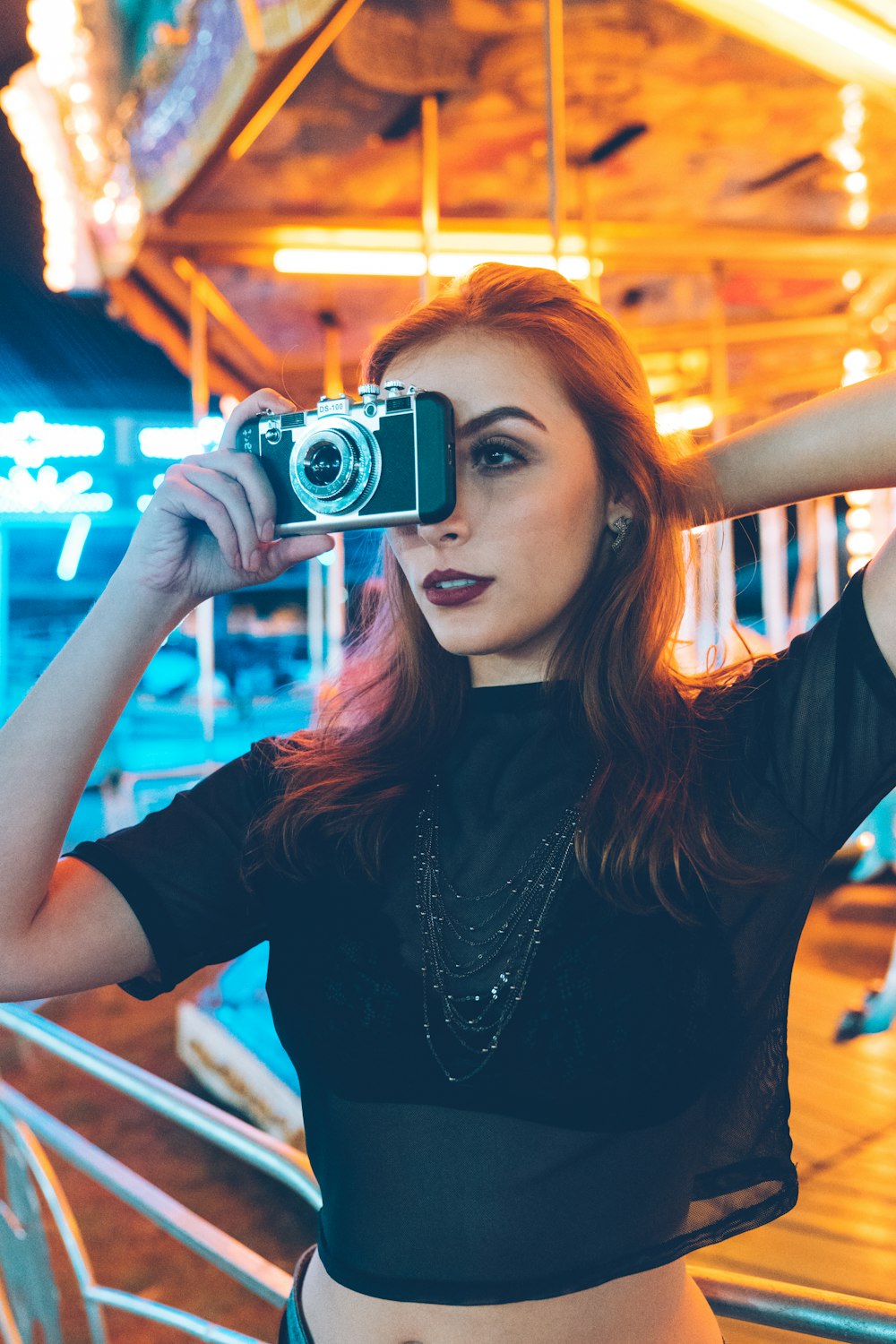 selective focus photo of woman holding black compact camera