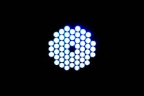 A circular arrangement of small, brightly lit LED lights against a black background. The LEDs emit a cool blue-white light and are tightly packed in a symmetrical pattern.