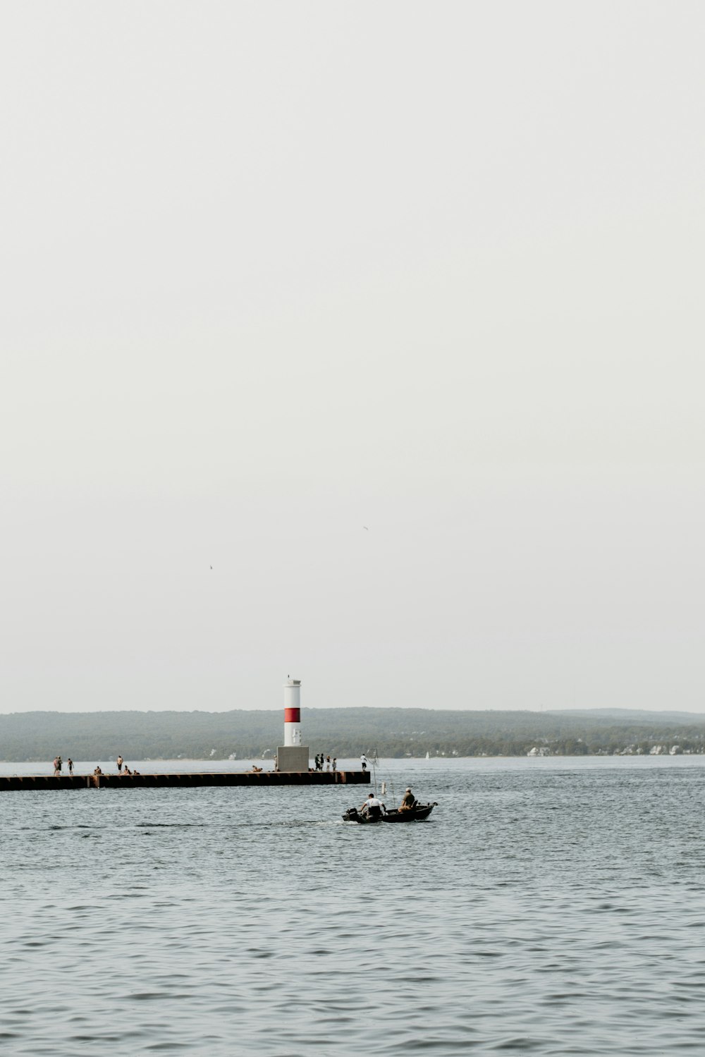 boat on body of water with lighthouse background