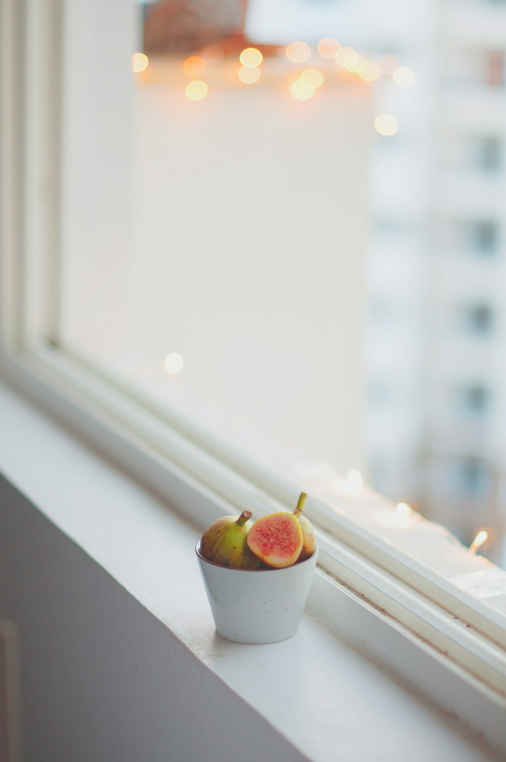 bowl of fruits on window sill