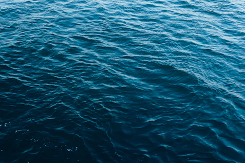 A panoramic view of a deep ocean with hexagonal patterns subtly overlaying the waves.