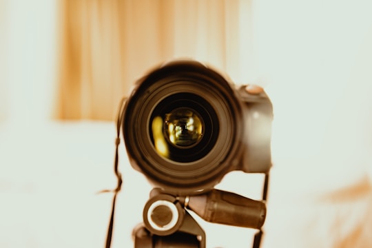 A close-up of a camera lens focusing on a subject in a studio setting.
