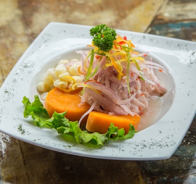 vegetable salad on white plate on brown table