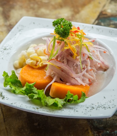 vegetable salad on white plate on brown table