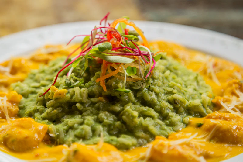 A plated Peruvian dish — meat in a yellow and green sauce