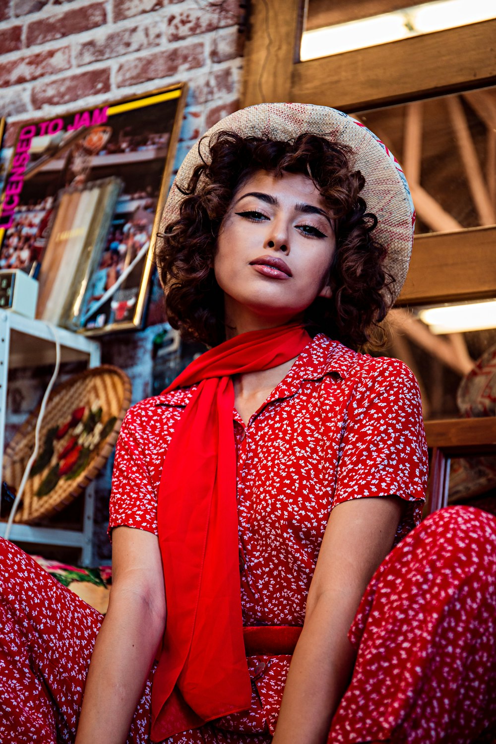 mulher vestindo vestido vermelho e branco e cachecol com chapéu marrom