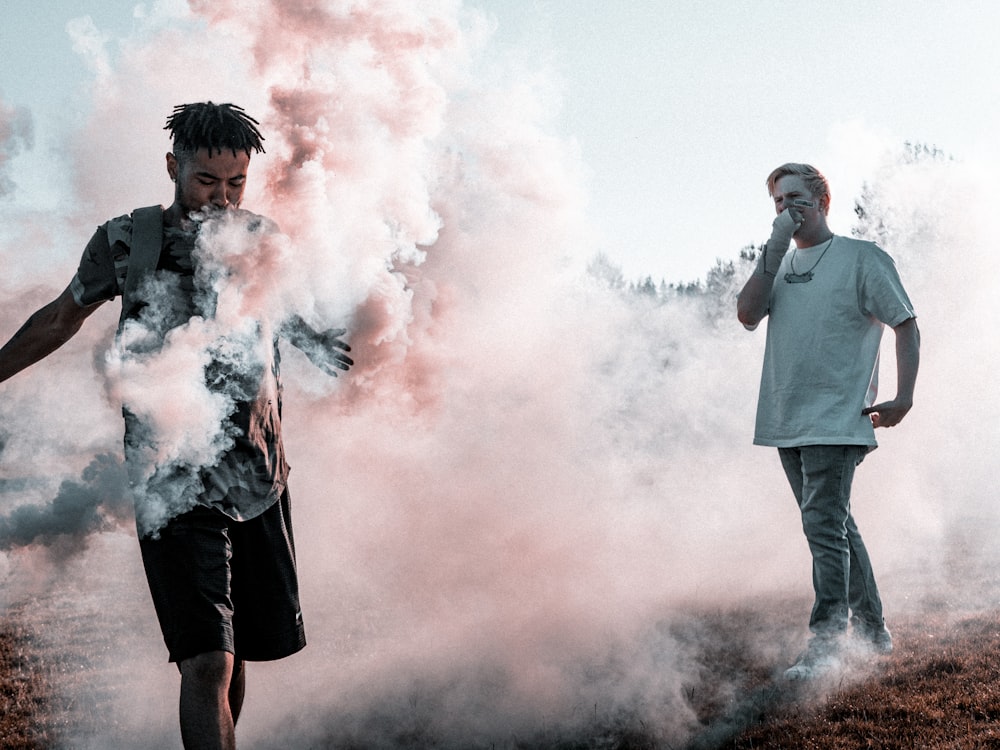two person surrounded with smokes