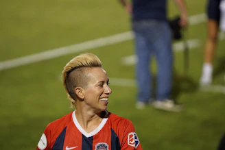 Portrait of a determined footballer smiling confidently with team colors in the background.