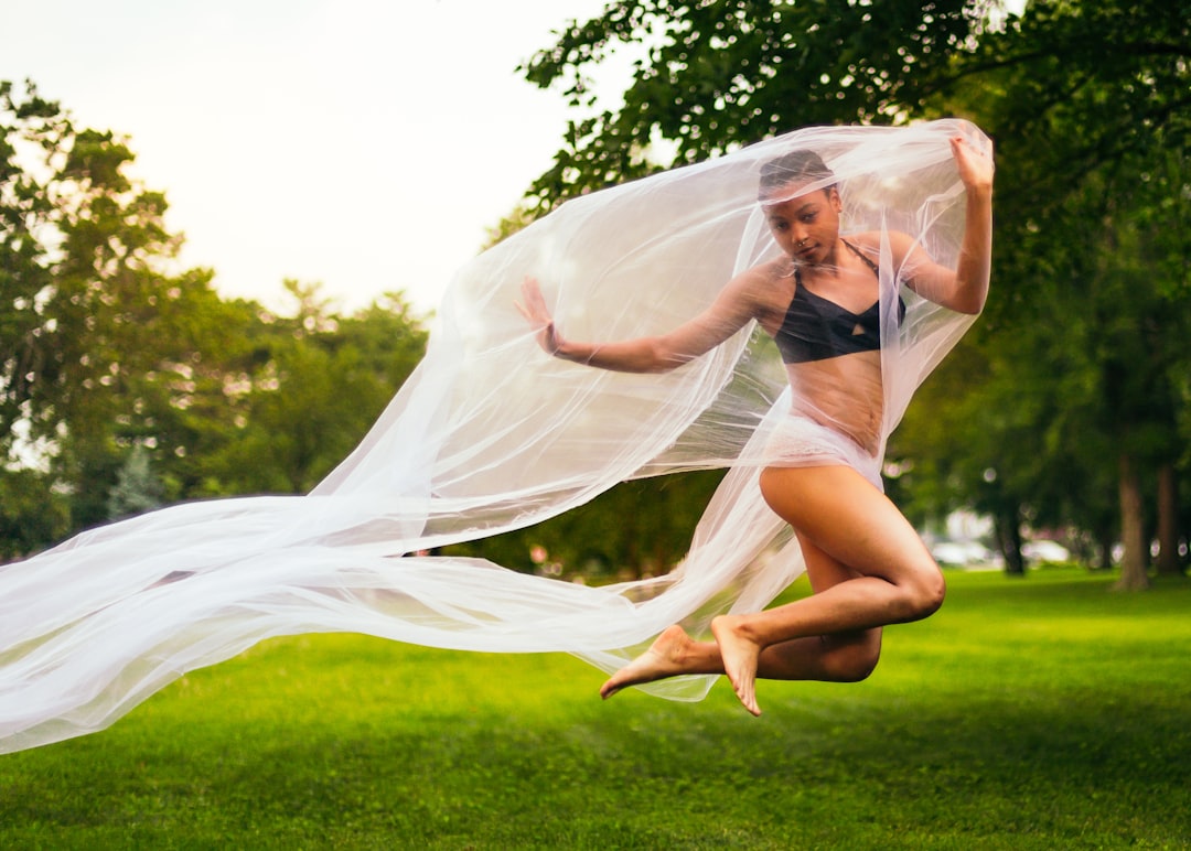 woman holding mesh cloth while jumping