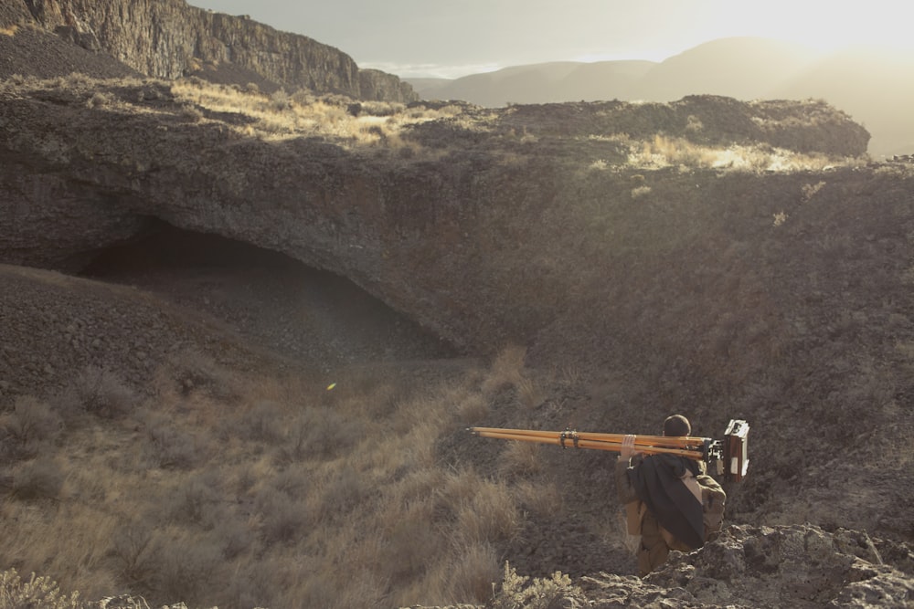 person holding camera on mountain during daytime