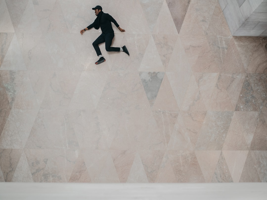 man wearing black clothes lying on the floor, I love using structure and infusing a human element into them to see how t