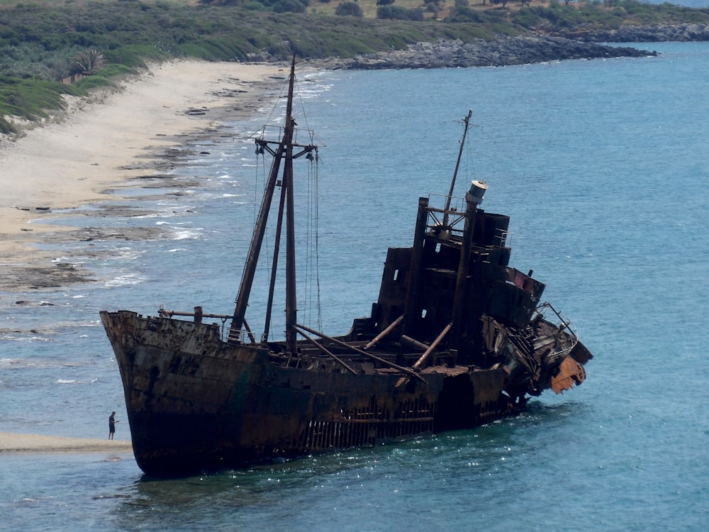 person standing near ship on seashore