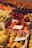 A variety of fresh fruits are neatly arranged in boxes at a market. The selection includes citrus fruits, apples, plums, figs, and peaches. Each box is labeled with handwritten signs displaying prices or names. The scene is colorful and vibrant, highlighting the abundance of fresh produce available.