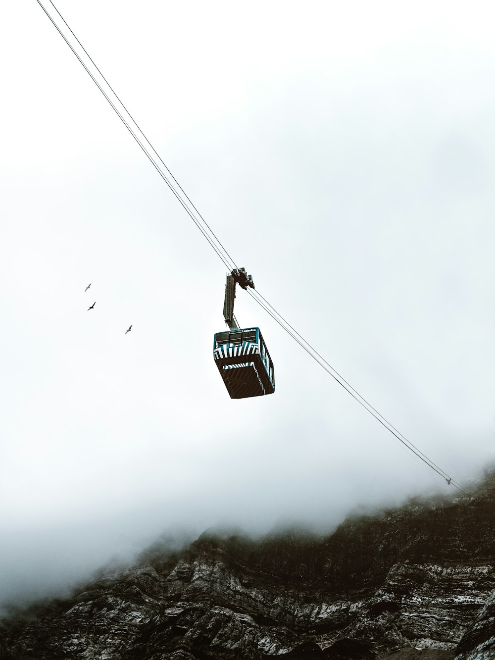 worm's eye view of cable tram under gray sky