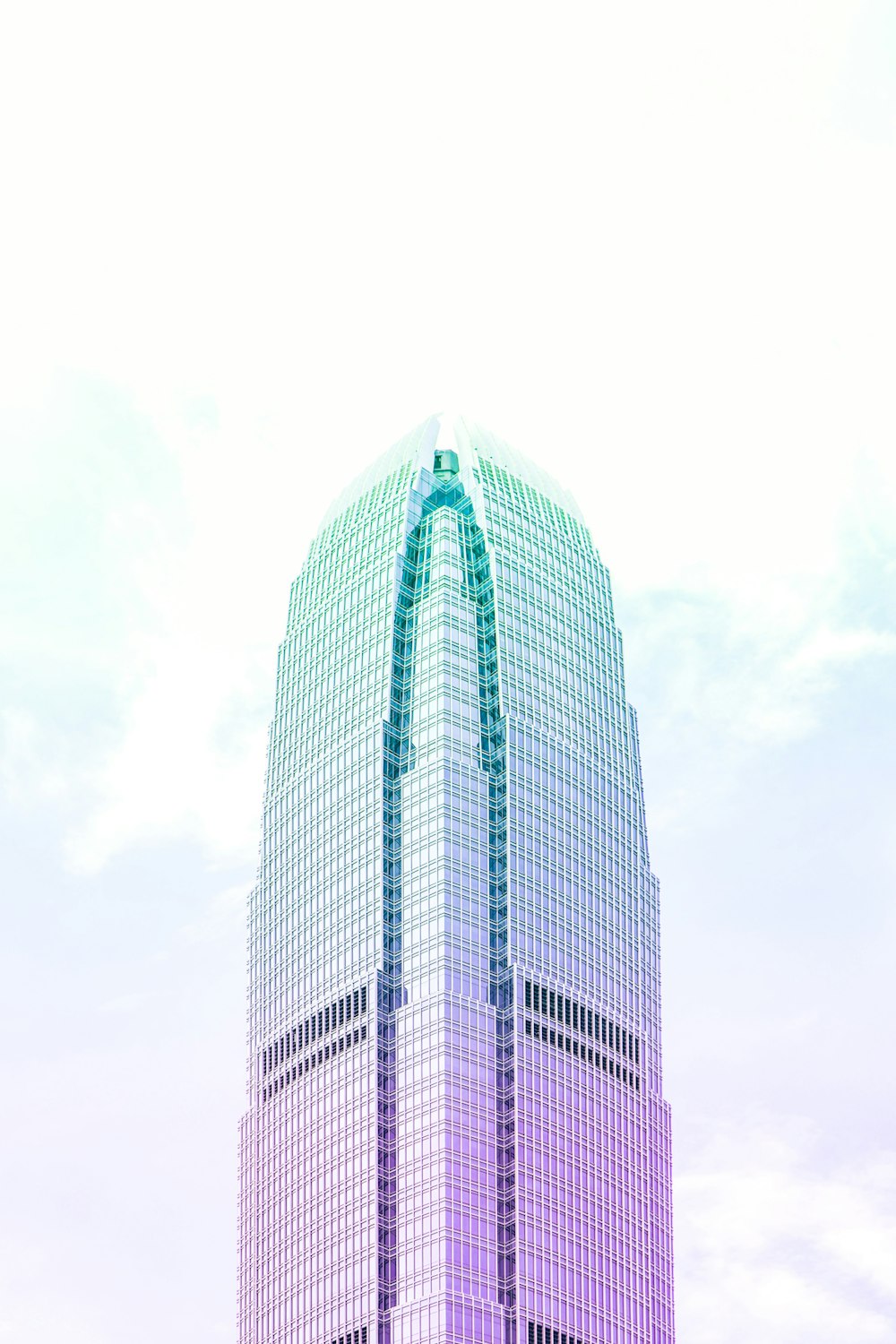 ティールとピンクの高層ビルのローアングル写真