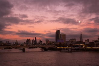 Abstract image of digital waves flowing over a city skyline at dusk