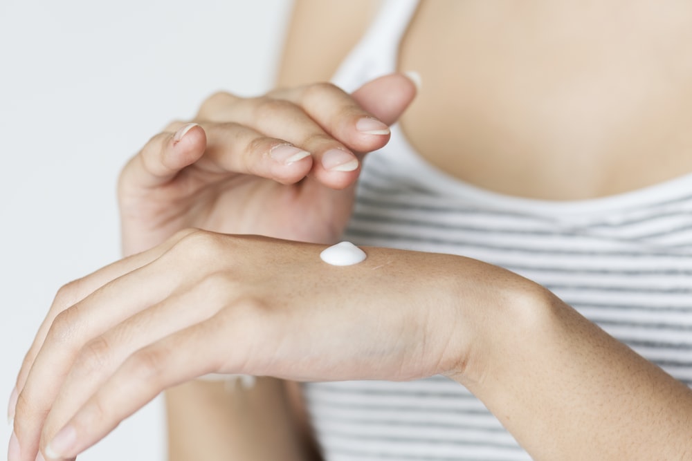 white cream on woman's hand