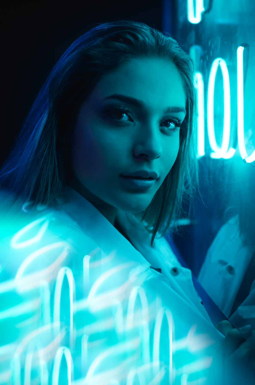 photo en gros plan d’une femme près d’une enseigne lumineuse au néon